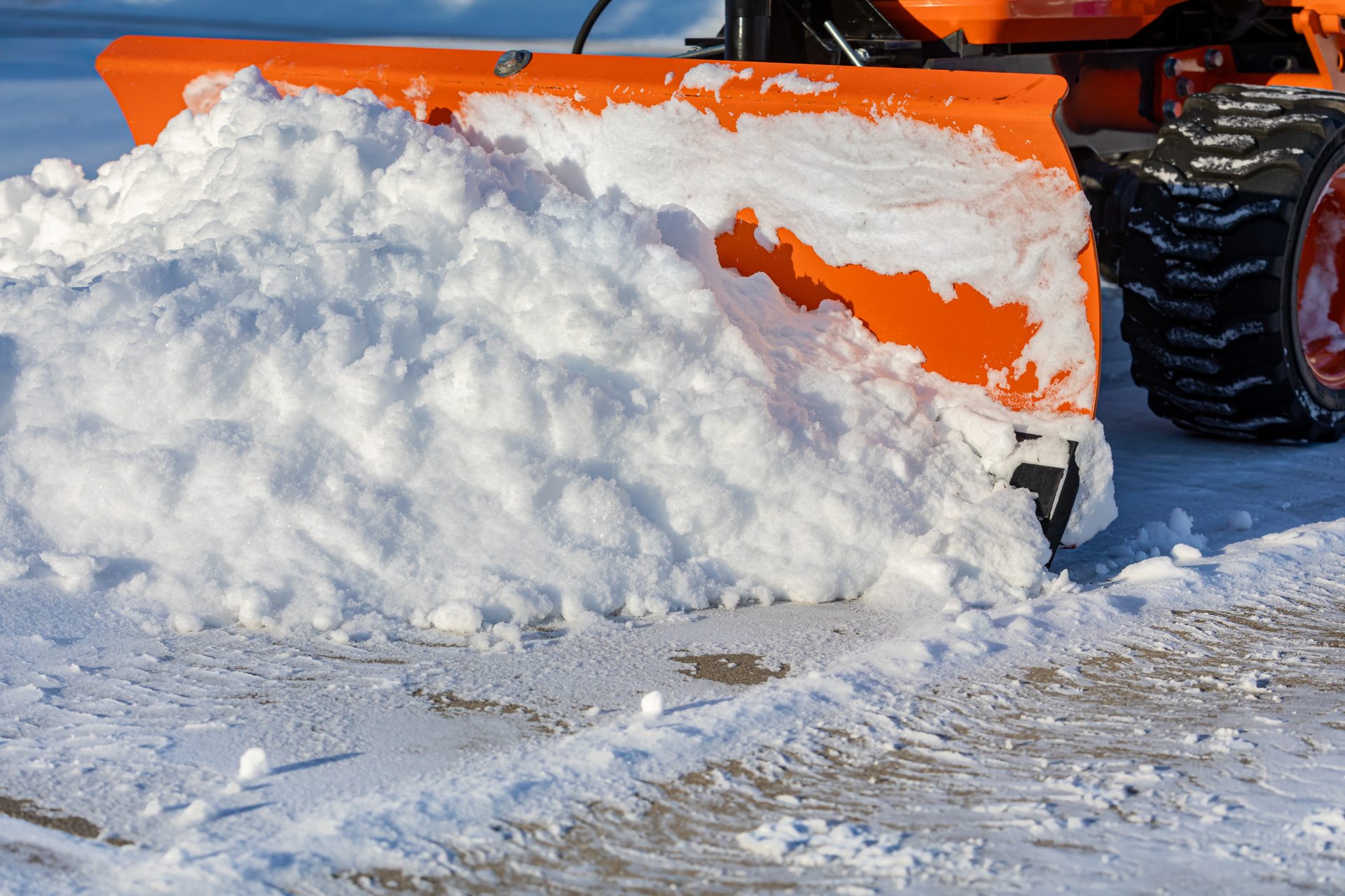 Commercial snow removal — loader clearing a Colorado parking lot